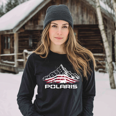 Woman wearing a black Polaris shirt with a mountain design in a snowy outdoor setting.