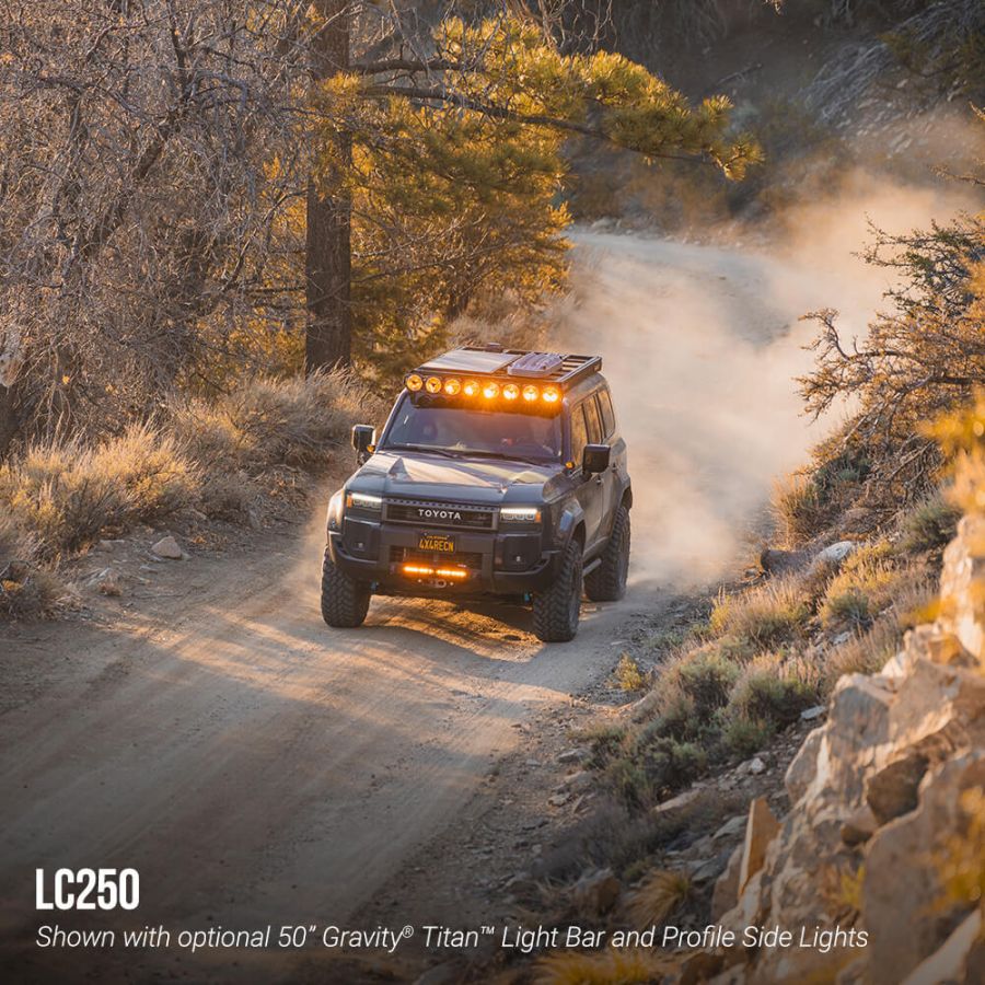 Toyota LC250 driving on a dirt road with optional light bar and side lights.