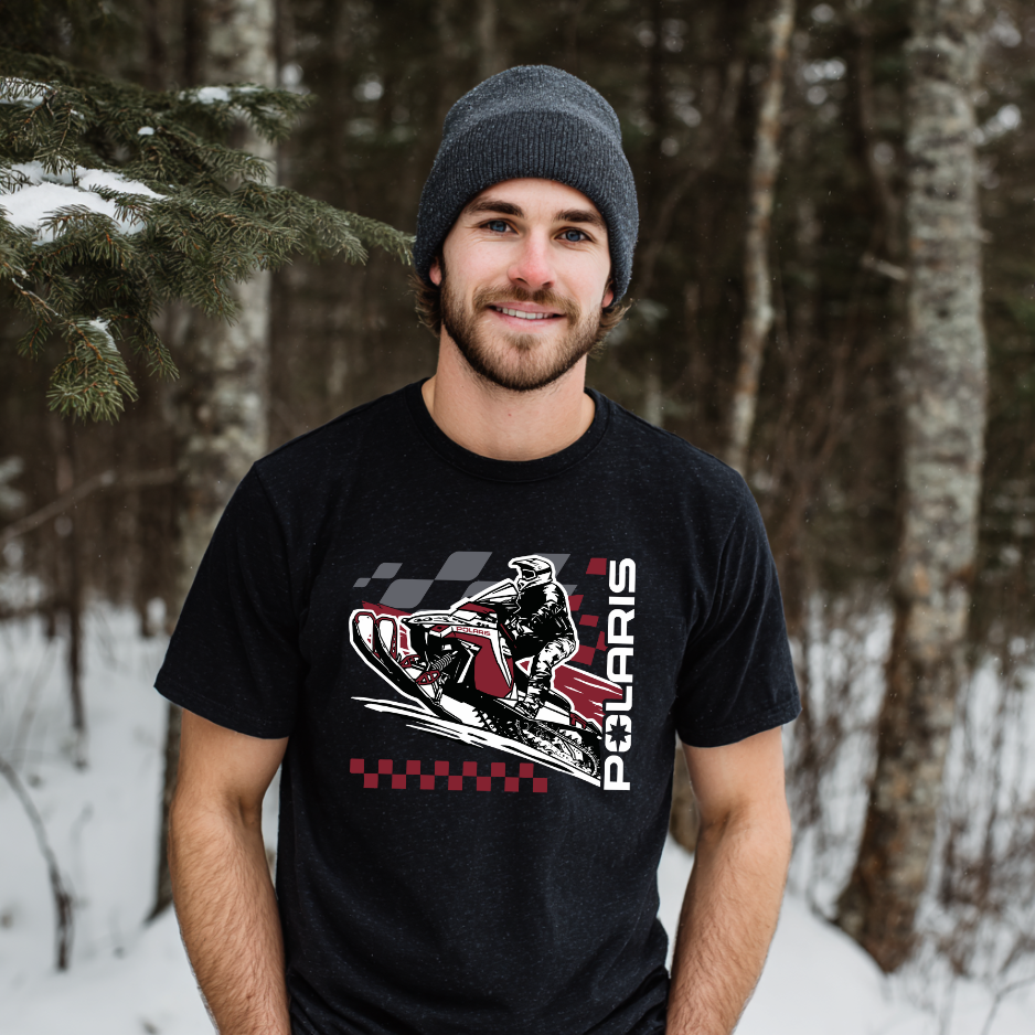 Man wearing a black t-shirt with a Polaris graphic in a snowy forest setting