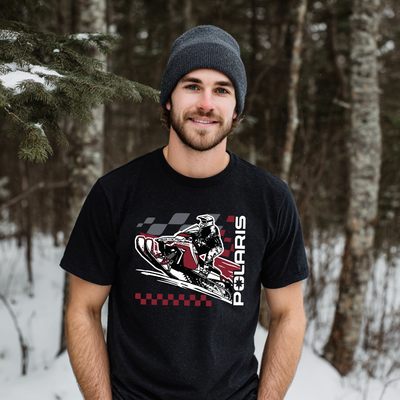 Man wearing a black t-shirt with a Polaris graphic in a snowy forest setting