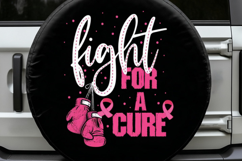 A black circular spare tire cover mounted on a vehicle, featuring the text &