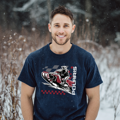 Man wearing a navy blue t-shirt with Polaris graphic in a snowy forest