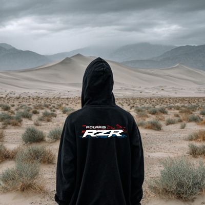 Person wearing a black hoodie with Polaris RZR logo in a desert landscape