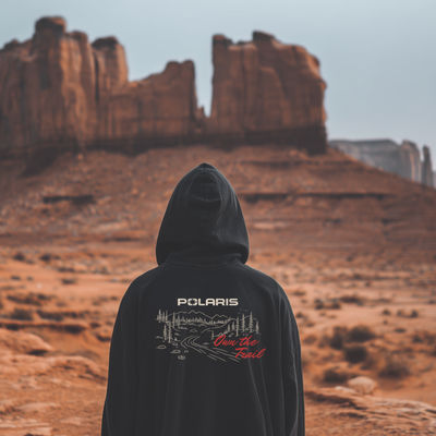 Person wearing a hoodie with 'Polaris' branding in a desert landscape