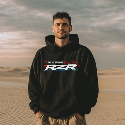 Man wearing a black hoodie with Polaris RZR logo in a desert setting