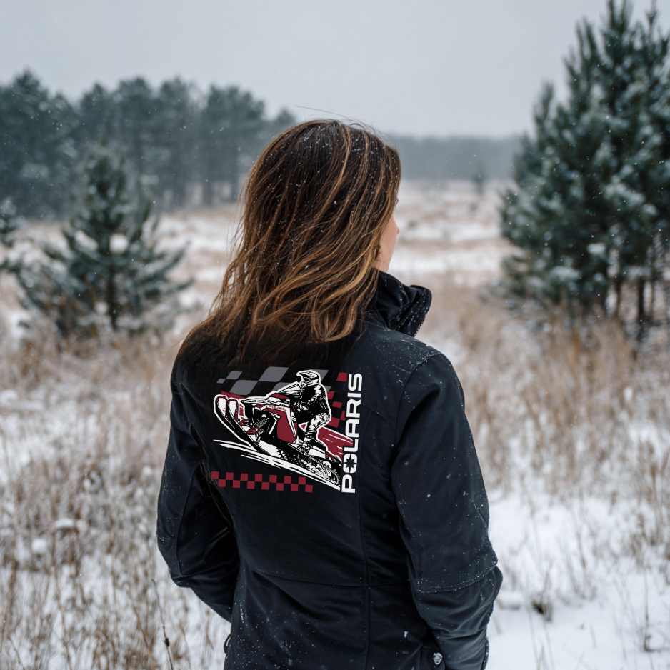 Person wearing a black jacket with Polaris logo in a snowy landscape