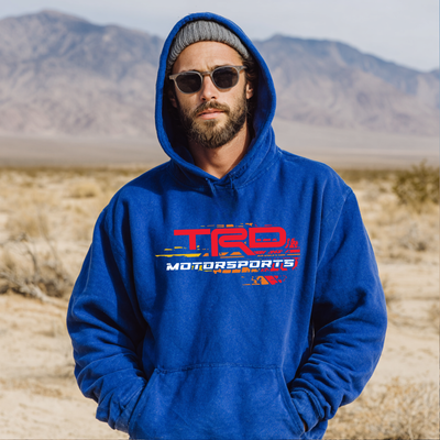 Man wearing a blue hoodie with TRD Motorsports logo in a desert setting